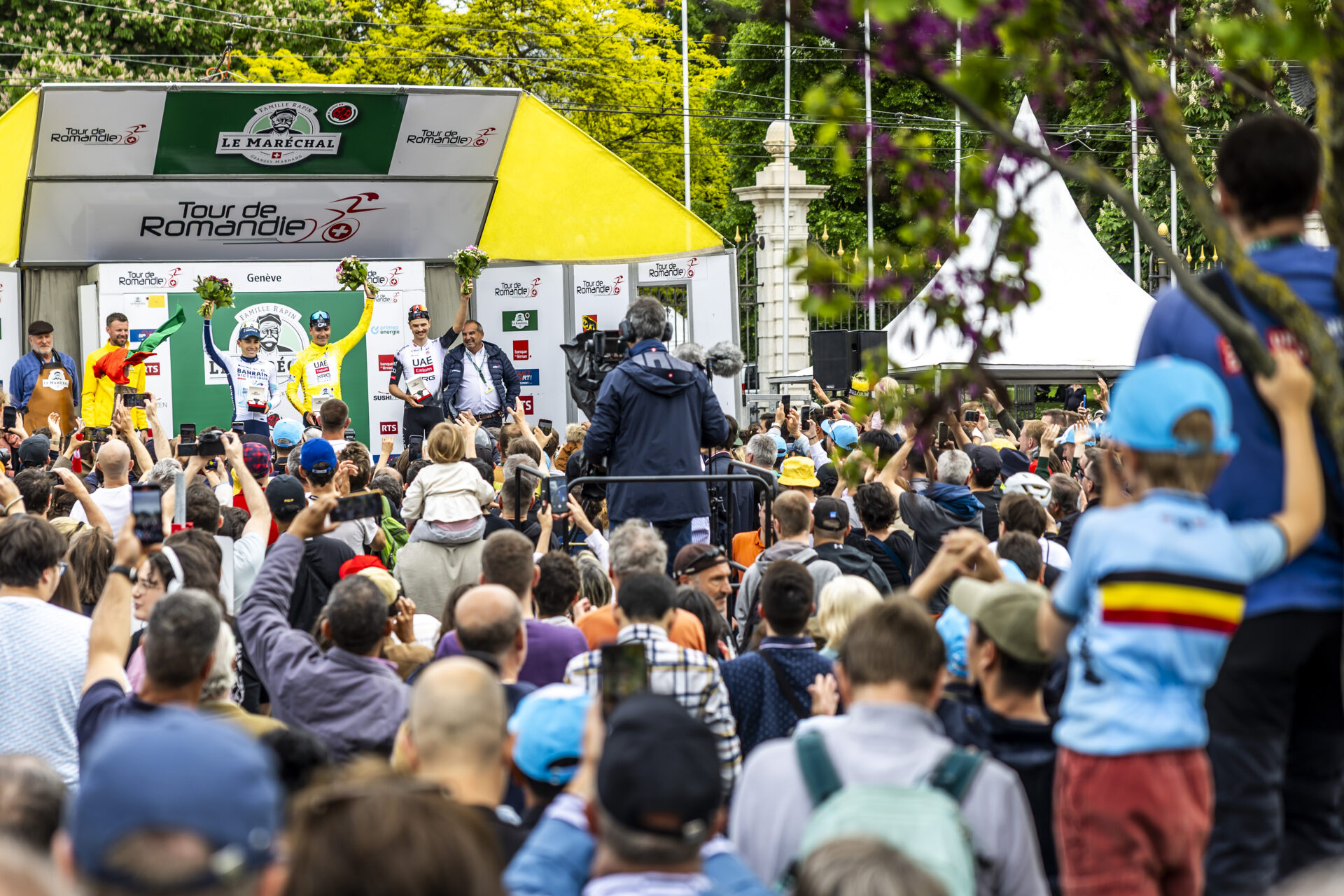The podium of the Tour de Romandie with second placed Lenny Martinez from France of team Bahrain Victorius, left, the winner Joao Almeida from Portugal of UAE Team Emirates XRG, center, and third placed Jay Vine from Australia of UAE Team Emirates XRG, right, celebrate on the podium after the fifth and final stage, a 17,1 km race against the clock at the 78th Tour de Romandie UCI World Tour Cycling race, in Geneva, Switzerland, Sunday, May 4, 2025. (KEYSTONE/Salvatore Di Nolfi)