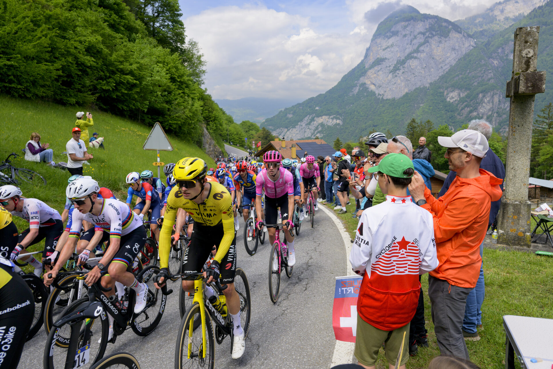 The pack of riders with Tadej Pogacar, left in white, from Slovenia of UAE Team Emirates XRG in action as they climb La Rasse during the first stage, a 170,6 km race around Martigny at the 79th Tour de Romandie UCI World Tour Cycling race, in Saint-Maurice, Switzerland, Wednesday, April 29, 2026. (KEYSTONE/Jean-Christophe Bott)